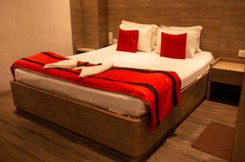 a large bed with a red blanket on it at Hotel Aerocity Golden Near IgI New Delhi Airport in New Delhi