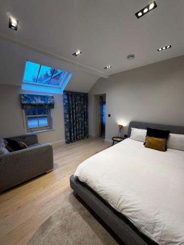 una camera da letto con un letto grande e un divano di The stables at the Grange a York