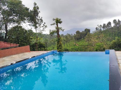 a blue swimming pool with a mountain in the background at Green Garden Deluxe Room in Vayittiri