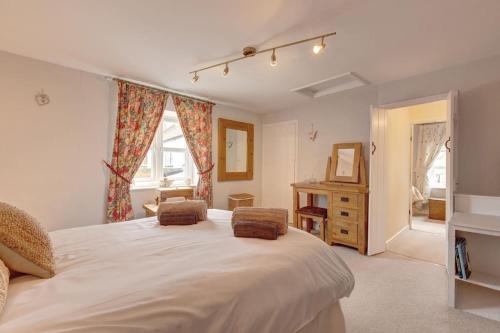 Un dormitorio con una gran cama blanca y una ventana en Jack's Cottage - Wells-Next-The-Sea, en Wells-next-the-Sea