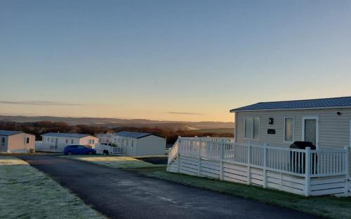 a white house with a fence next to a street at Alphi 4 in Bude