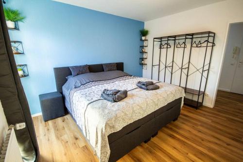 a bedroom with a large bed with blue walls at Fabrikdesign Düren in Düren - Eifel