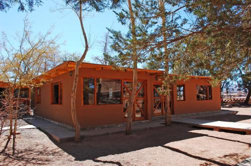 a house under construction with trees in the foreground at Quechua Hotel in San Pedro de Atacama