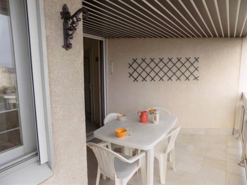 - une table et des chaises blanches dans la chambre dans l'établissement Vaux sur Mer - Quartier de PONTAILLAC - APPARTEMENT résidence LA FREGATE, à Vaux-sur-Mer