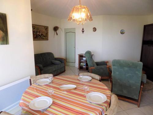 d'un salon avec une table et des plaques de cuisson. dans l'établissement Vaux sur Mer - Quartier de PONTAILLAC - APPARTEMENT résidence LA FREGATE, à Vaux-sur-Mer