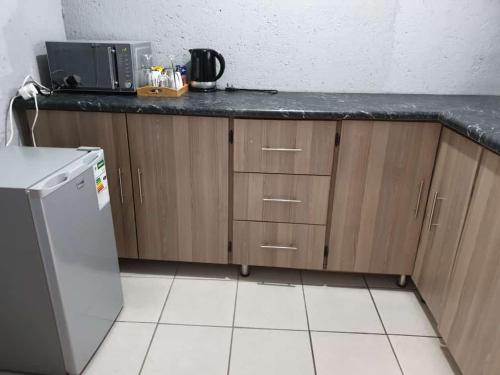 La cuisine est équipée d'un comptoir et d'un réfrigérateur. dans l'établissement Tsamatiku Villa Guesthouse, à Hazyview