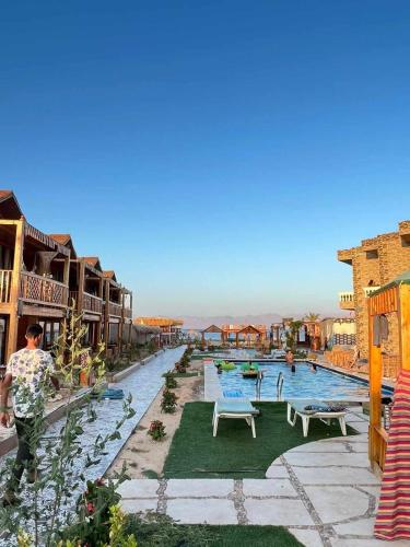 a pool at a resort with people walking around it at Green Beach Camp & Hotel in Nuweiba
