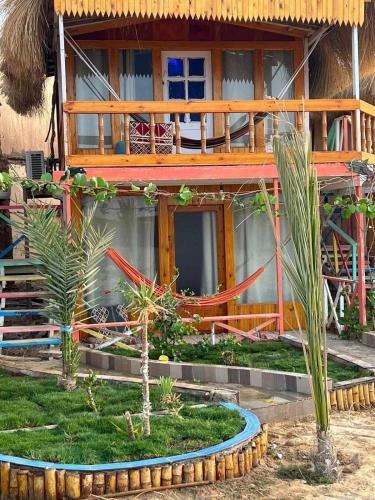 a house with a garden in front of it at Green Beach Camp & Hotel in Nuweiba
