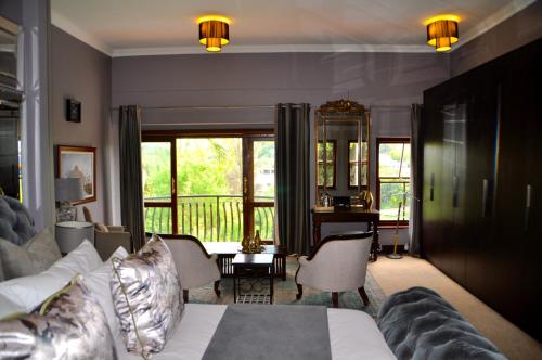 a living room with a couch and a balcony at Ambonnay Terrace Guest House in Pretoria