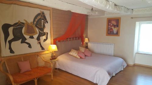 a bedroom with a bed and a horse painting on the wall at Clos St Ange (Dinan-St Malo) in Vildé-Guingalan