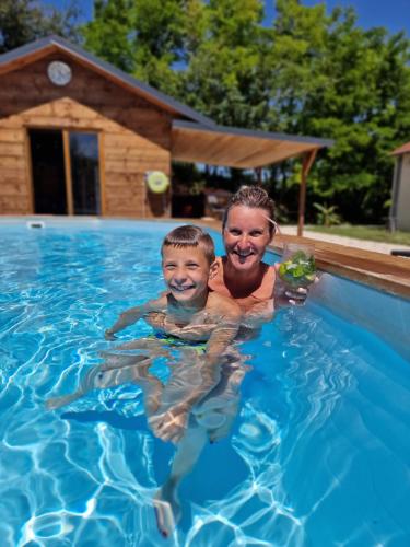une femme et un garçon dans une piscine dans l'établissement Domaine des Rigaud, à Garchizy