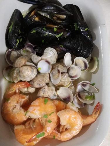 a plate of food with shrimp and mussels and oysters at Hotel Grazia Ristorante in LʼAquila
