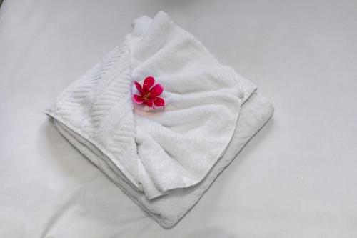 a white towel with a red flower on it at 2-BR London Oasis in Woolwich in London