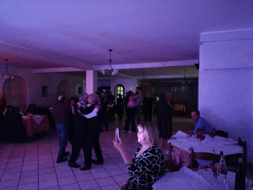 a woman taking a picture of a group of people at a party at Hotel Grazia Ristorante in LʼAquila