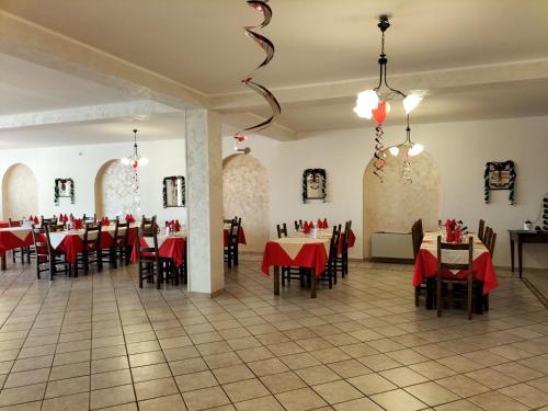 un comedor con mesas, sillas y manteles rojos en Hotel Grazia Ristorante, en LʼAquila