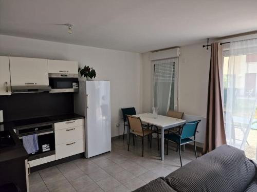 eine Küche und ein Esszimmer mit einem Tisch und Stühlen in der Unterkunft Duplex avec terrasse et jardin in Dammarie-les-Lys