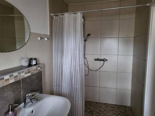 a bathroom with a shower curtain and a sink at Zimmervermietung Kirchlengern in Kirchlengern