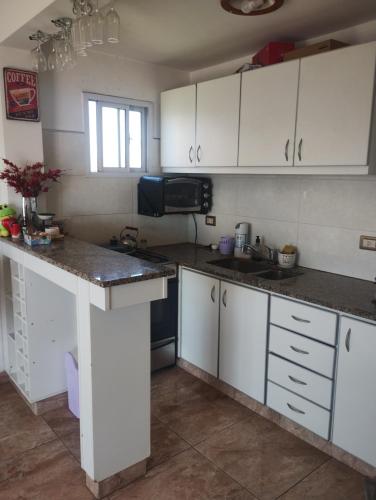eine Küche mit weißen Schränken und einem Waschbecken in der Unterkunft Departamento frente al mar in Mar del Plata