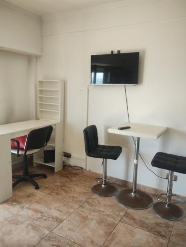 ein Büro mit 2 Stühlen, einem Tisch und einem Schreibtisch in der Unterkunft Departamento frente al mar in Mar del Plata