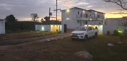 une voiture blanche garée devant une maison dans l'établissement Tsamatiku Villa Guesthouse, à Hazyview