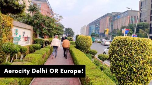 two people walking down a sidewalk in a city at Hotel Aerocity Golden Near IgI New Delhi Airport in New Delhi