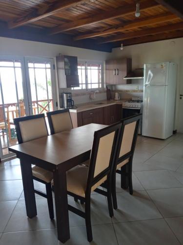 La cuisine est équipée d'une table, de chaises et d'un réfrigérateur. dans l'établissement Cabaña Las Palmeras, à El Soberbio