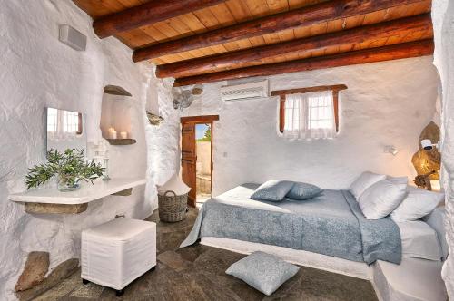 a bedroom with a bed and a wooden ceiling at White River Cottages - rustic minimalist holiday houses in Makry Gialos