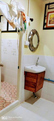 a bathroom with a sink and a mirror on the wall at Manu V House in Phra Nakhon Si Ayutthaya