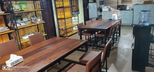 2 Holztische und -stühle in einem Zimmer mit Büchern in der Unterkunft Manu V House in Phra Nakhon Si Ayutthaya