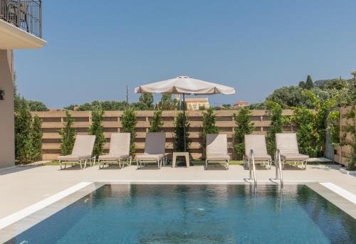 a pool with chairs and an umbrella on a patio at Luxury Villa Chrisi in Svoronata