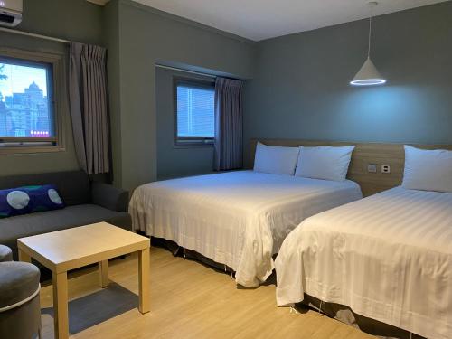 a hotel room with two beds and a couch at Prince Hotel in Jiaoxi