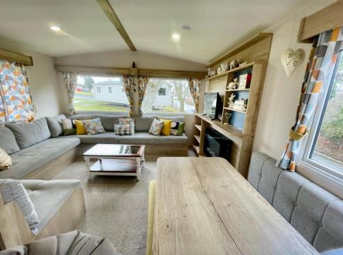 a living room with a couch and a table at Janet's Beautiful Country Caravan in Pwllheli
