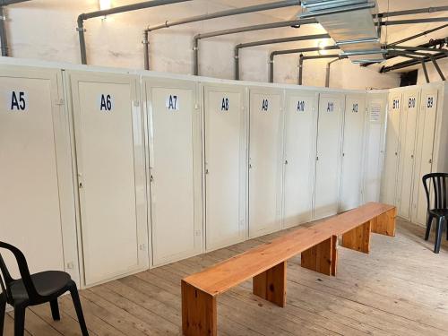 a row of white lockers with a wooden bench at Suite Lady Marian in Roccaraso