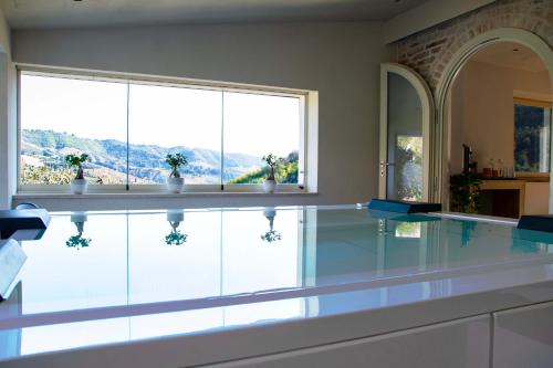una piscina con suelo de cristal y 2 ventanas en Colle Serrano Relais & SPA, en Ripatransone