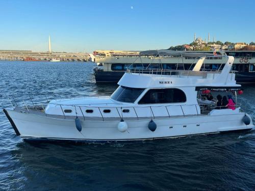 a white boat in the water with two other boats at Merza yatcılık in Istanbul