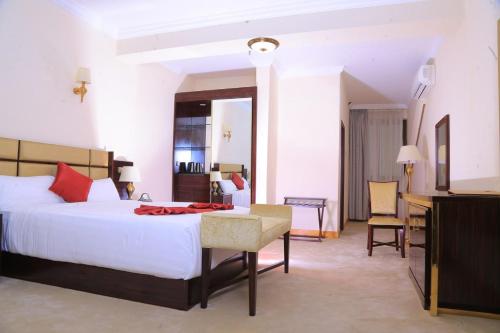 sypialnia z dużym białym łóżkiem i biurkiem w obiekcie Sunland International Hotel w Addis Abebie