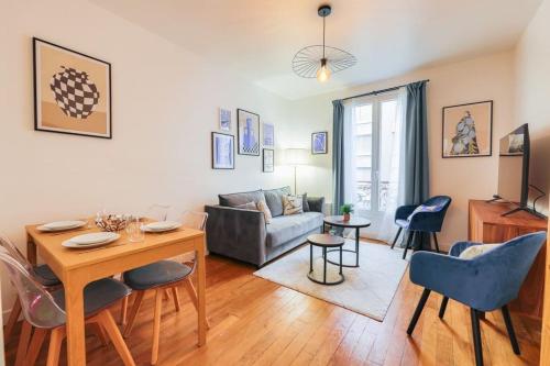 un salon avec une table et un canapé dans l'établissement Appartement spacieux -1BDR/4P -Le bas Montmartre, à Paris