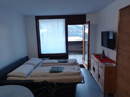 a bedroom with two beds and a large window at Petite Maison Larice in Pila