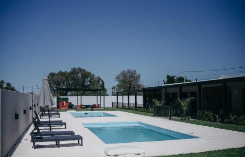 - une piscine avec des chaises longues à côté d'un bâtiment dans l'établissement Vento Hotel, à María Grande