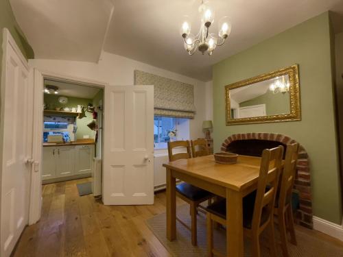 uma cozinha e sala de jantar com mesa e cadeiras em Spa Cottage em Braithwaite