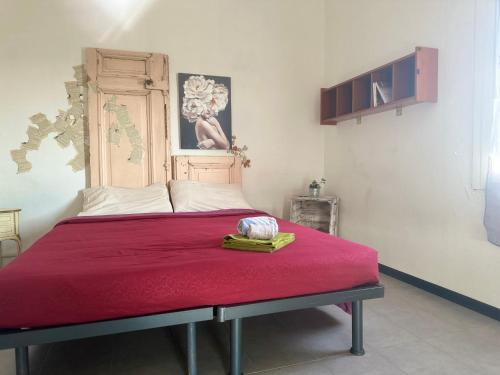 a bedroom with a large bed with a red blanket at K.tripla in San Giorgio