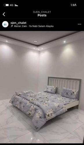 um quarto com uma cama com um edredão e almofadas em شالية أوجن em Unayzah
