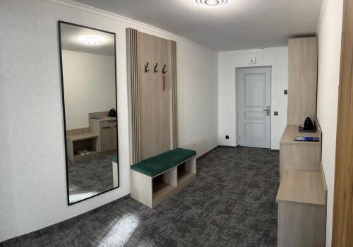 a bathroom with a mirror and a green bench at Prykarpattya in Ivano-Frankivsʼk