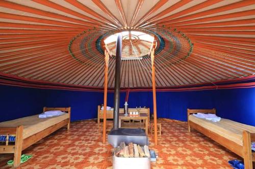 um quarto com uma tenda com 2 camas e um fogão em maidar-san tourist camp 