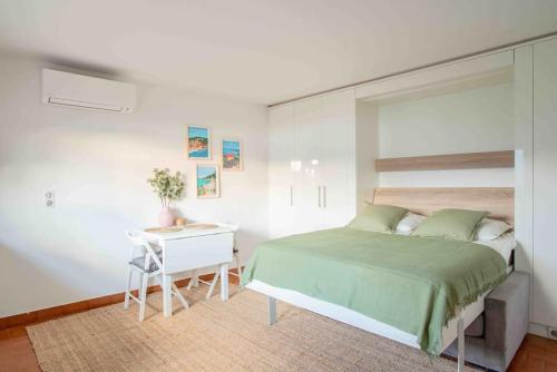 a bedroom with a bed and a table and a desk at Studio vue mer climatisé à 100m des plages in Saint-Jean-Cap-Ferrat