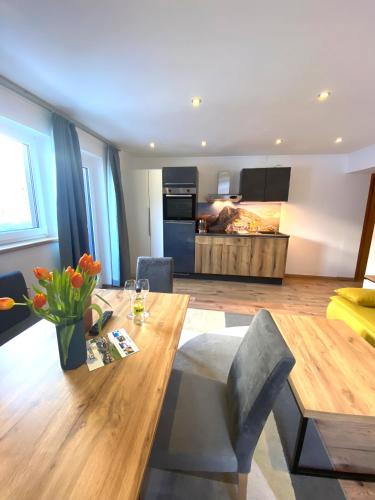 a living room with a wooden table and a kitchen at GRUBERS, Hotel Appartments Gastein in Bad Gastein