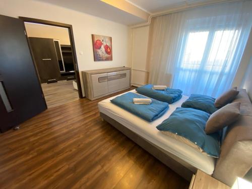 1 dormitorio con 1 cama grande con almohadas azules en Modern city-center apartment, en Debrecen