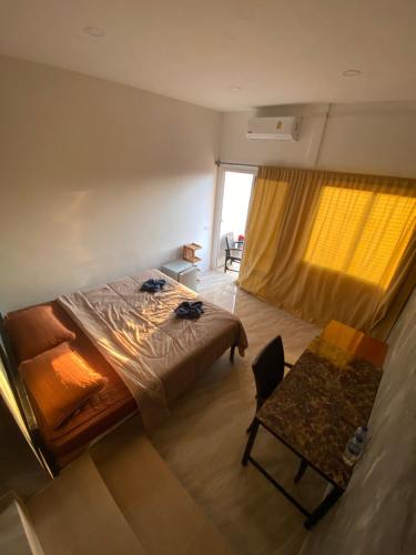 a bedroom with a bed and a table and a window at Phang Nga Viewpoint in Phangnga