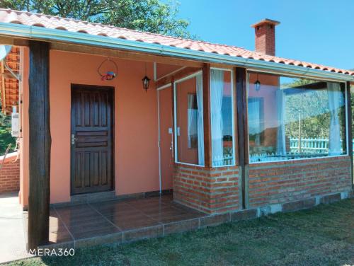 a house with glass doors and a porch at Chalé Mirante Da Guapiara in Aiuruoca