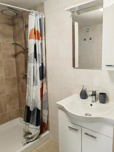 a bathroom with a shower curtain and a sink at Apartma Bela in Bohinjska Bela